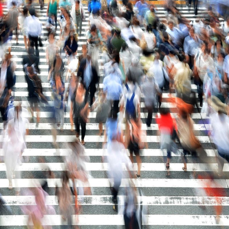 Blurred crowd crossing a busy street, illustrating toggling between calm and crazy.