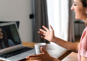 Woman smiling at a friend during a video call, connecting deeply across distance.