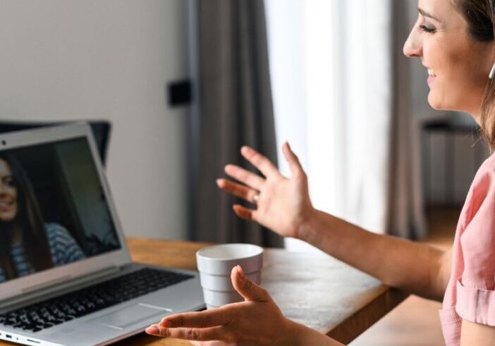 Woman smiling at a friend during a video call, connecting deeply across distance.