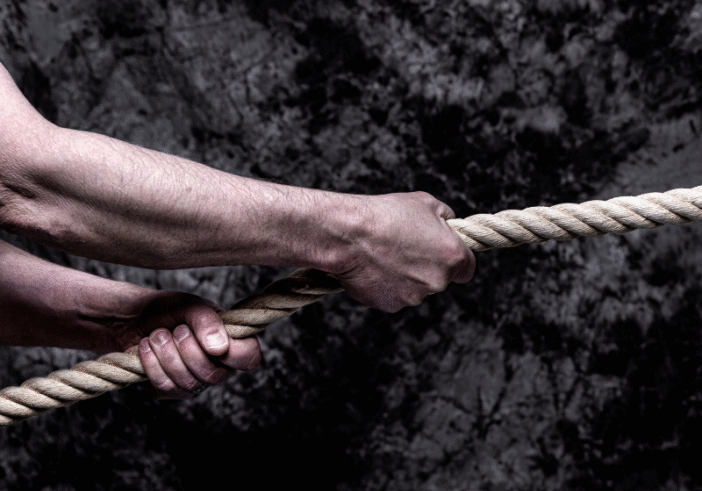 Close-up of hands pulling a rope in a tug-of-war, representing resistance and struggle.
Description: A close-up image showing hands pulling tightly on a rope during a tug-of-war, symbolizing the effort and resistance often involved in trying to accept a situation versus the ease of surrender.